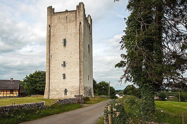 Medieval stone tower with lush greenery and a winding path in Ireland Ireland.