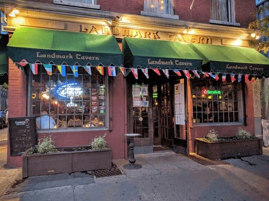 Cozy Irish pub with green awnings and colorful banners, inviting locals and visitors alike.