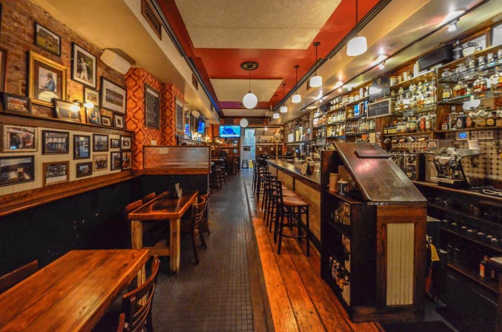 Cozy Irish pub interior with warm lighting, wooden furniture, and traditional decor.