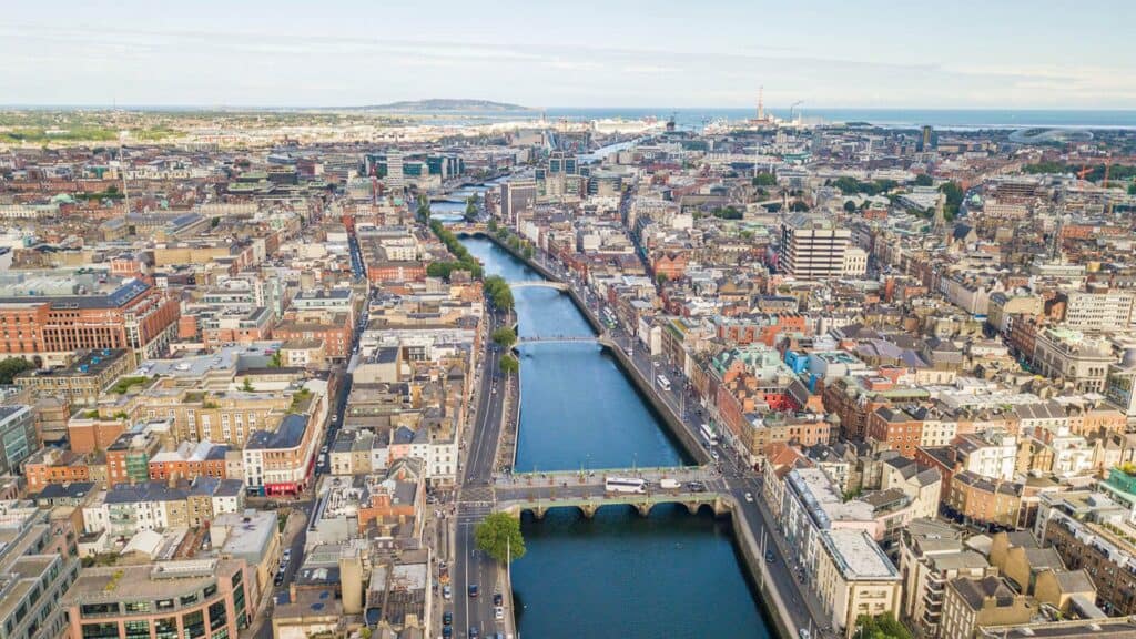 Breathtaking aerial view of Dublin's River Liffey crossing through the cityscape, showcasing historic bridges and vibrant urban life.