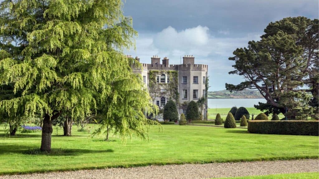 Luxurious Irish castle surrounded by lush green gardens and scenic landscape.