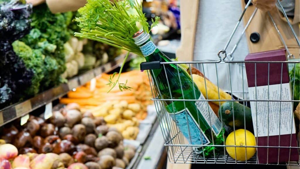 Fresh green herbs in a shopping basket at an Irish grocery store.