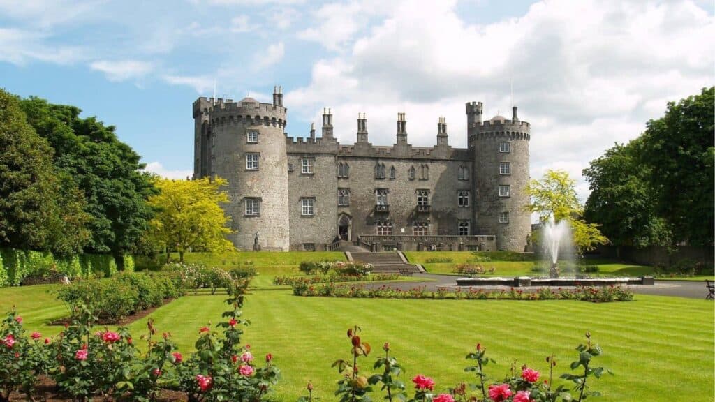 Lavender Castle in Ireland surrounded by lush gardens and colorful flowers.