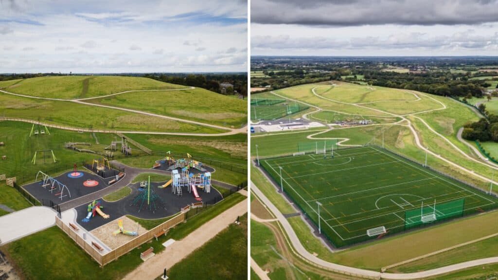 Vibrant playground with slides, swings, and open grassy fields, set against rolling green hills.