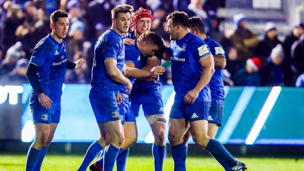 Celebrating rugby players in blue jerseys on the field during a match.