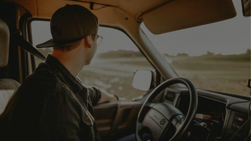 Boy driving a vintage Volkswagen van on a countryside road in Ireland.