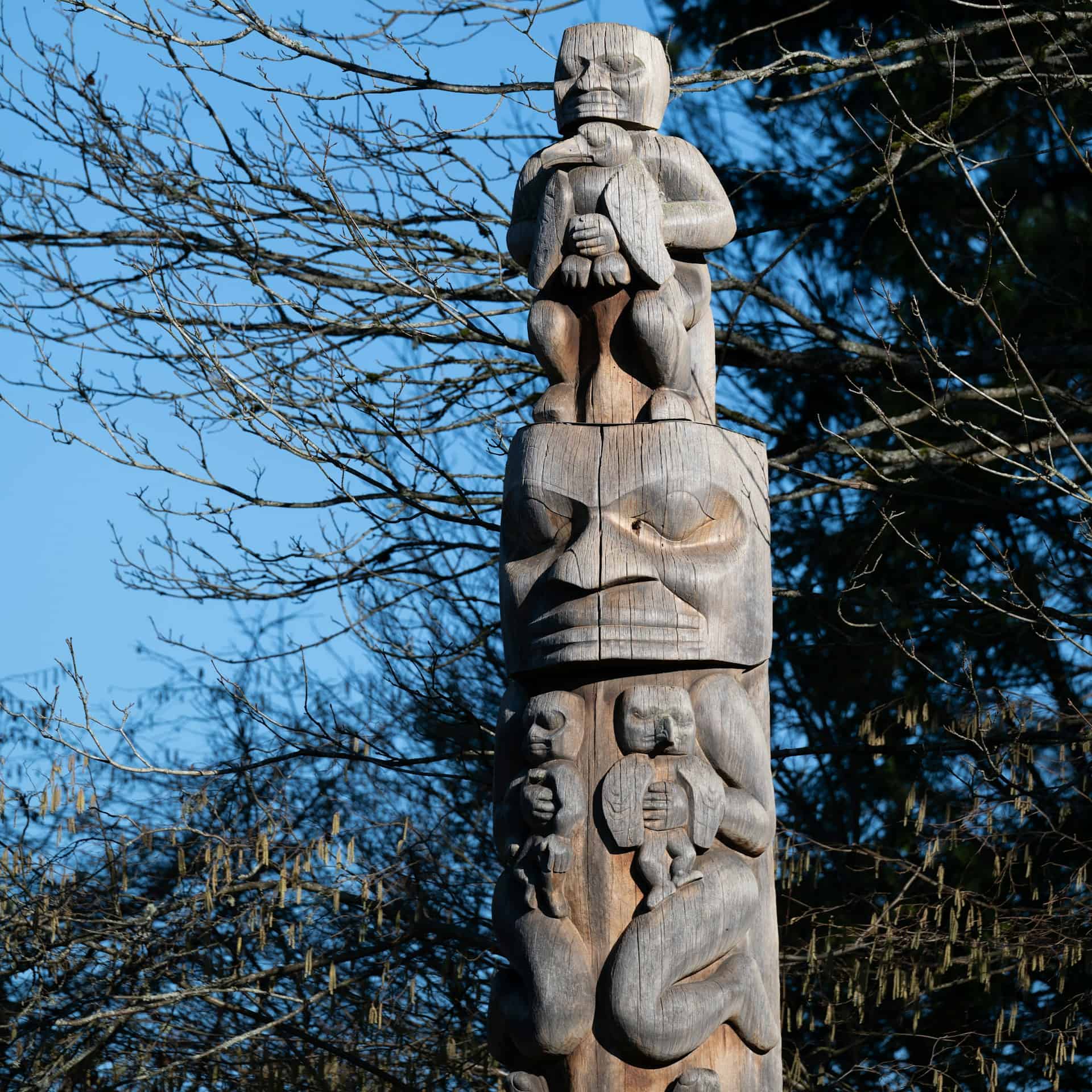 Hand-carved Irish wooden totem pole with mythological figures.