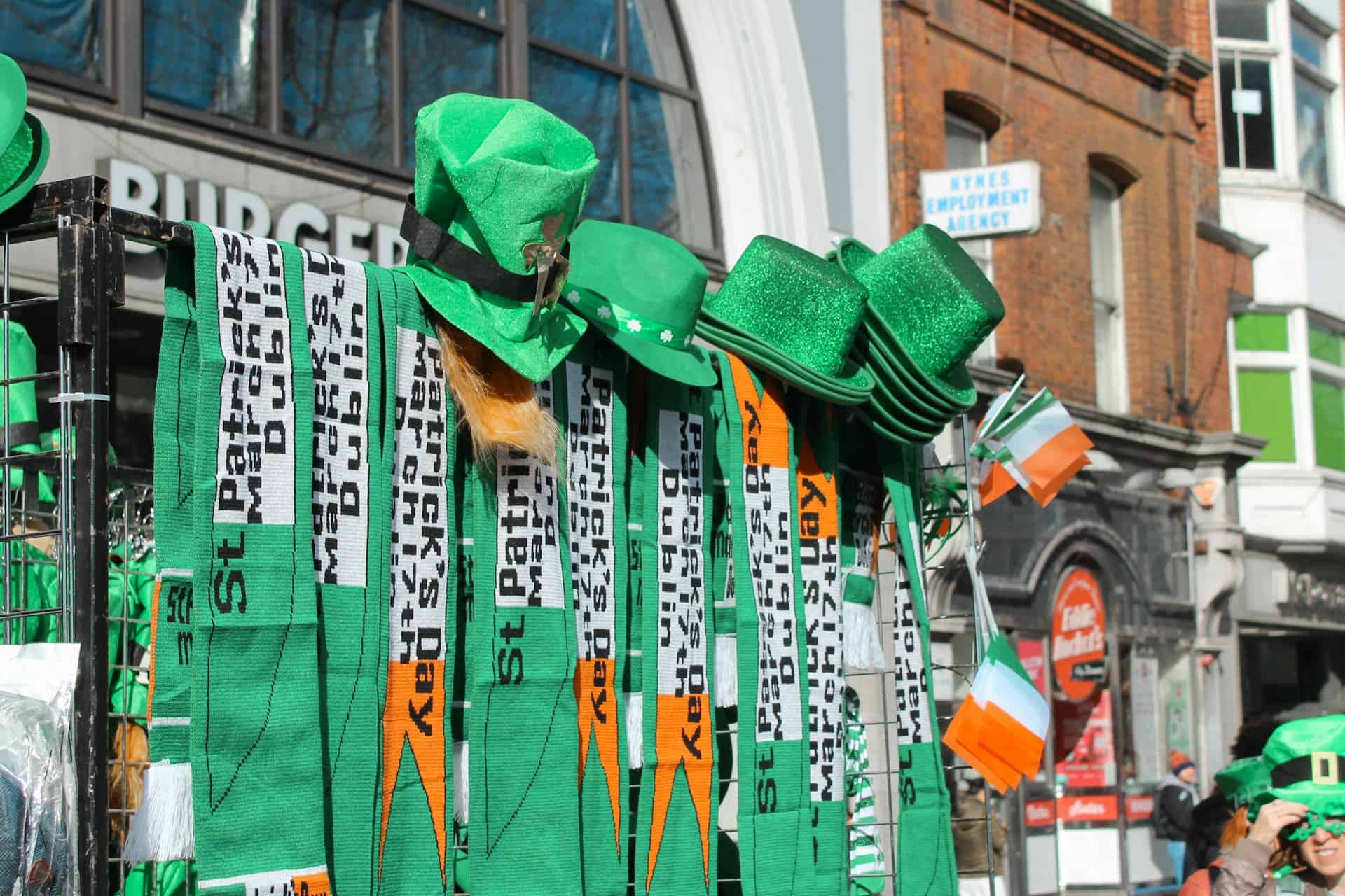 Colorful St. Patrick's Day hats, scarves, and accessories displayed outdoors in Dublin.