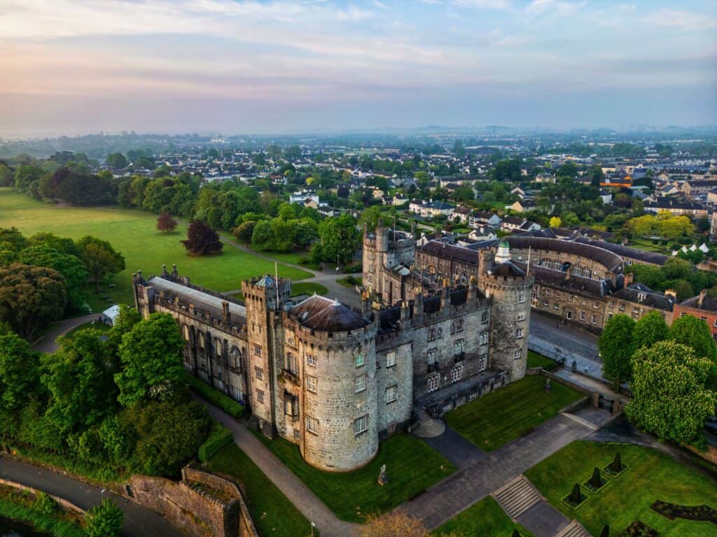 Stunning aerial view of medieval Kilkenny Castle and lush surroundings in Ireland.