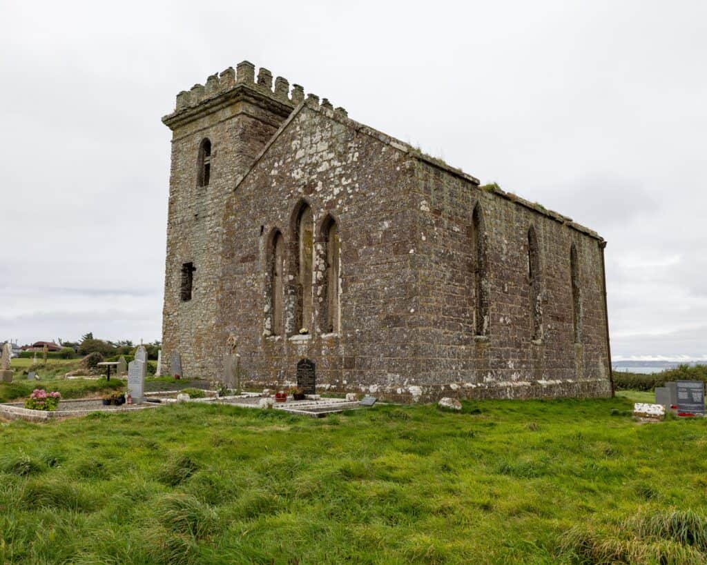 Historic stone church in Wexford, Ireland, showcasing medieval architecture in a serene setting.