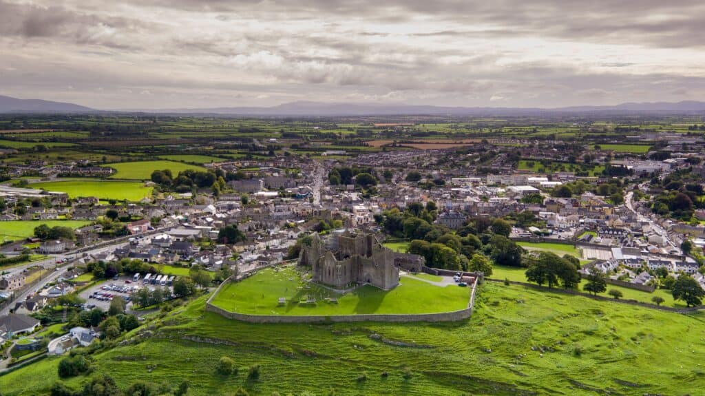 Aerial view of a historic castle surrounded by lush green countryside and a picturesque town.