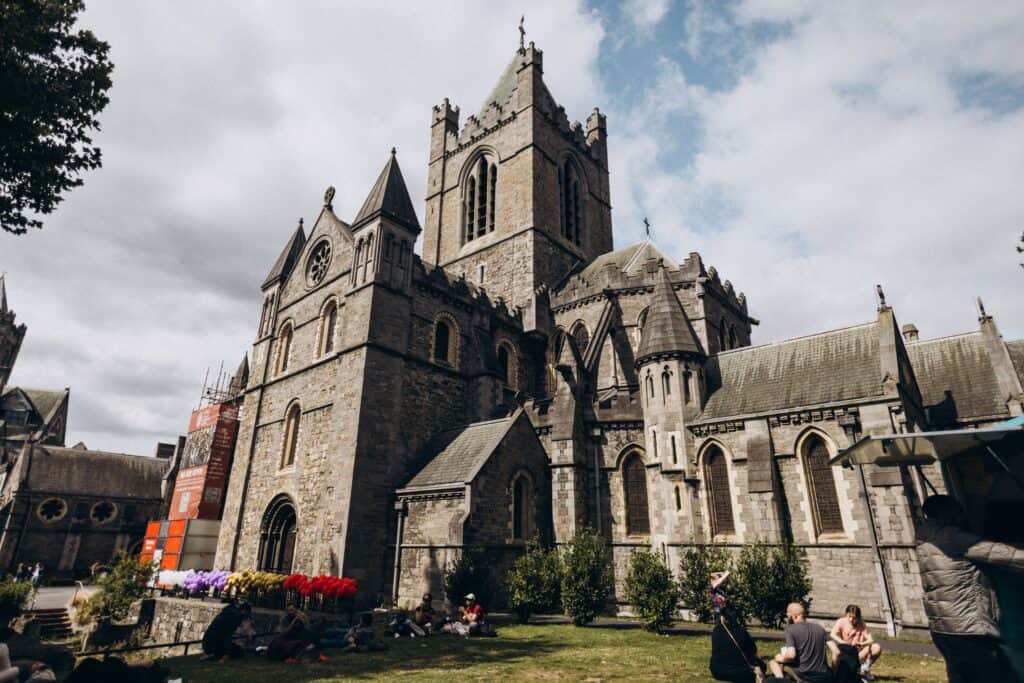 A vibrant view of Christ Church Cathedral, Dublin, on a sunny day, capturing its Gothic architecture and lively atmosphere.