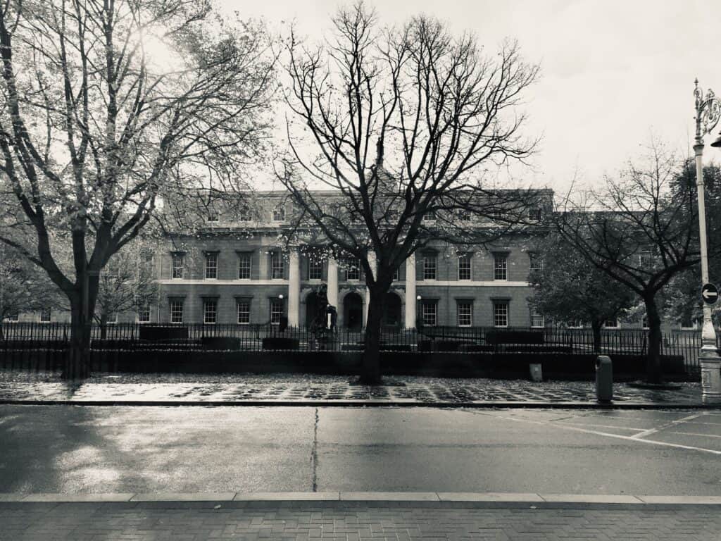 Monochrome view of a Georgian building in Dublin with trees lining the street.
