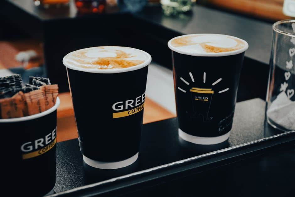 Close-up of three coffee cups with latte art at a café, showcasing a warm atmosphere.