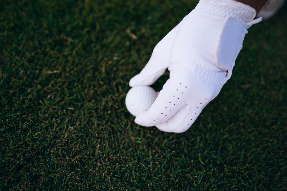 White golf glove on green grass in Ireland.