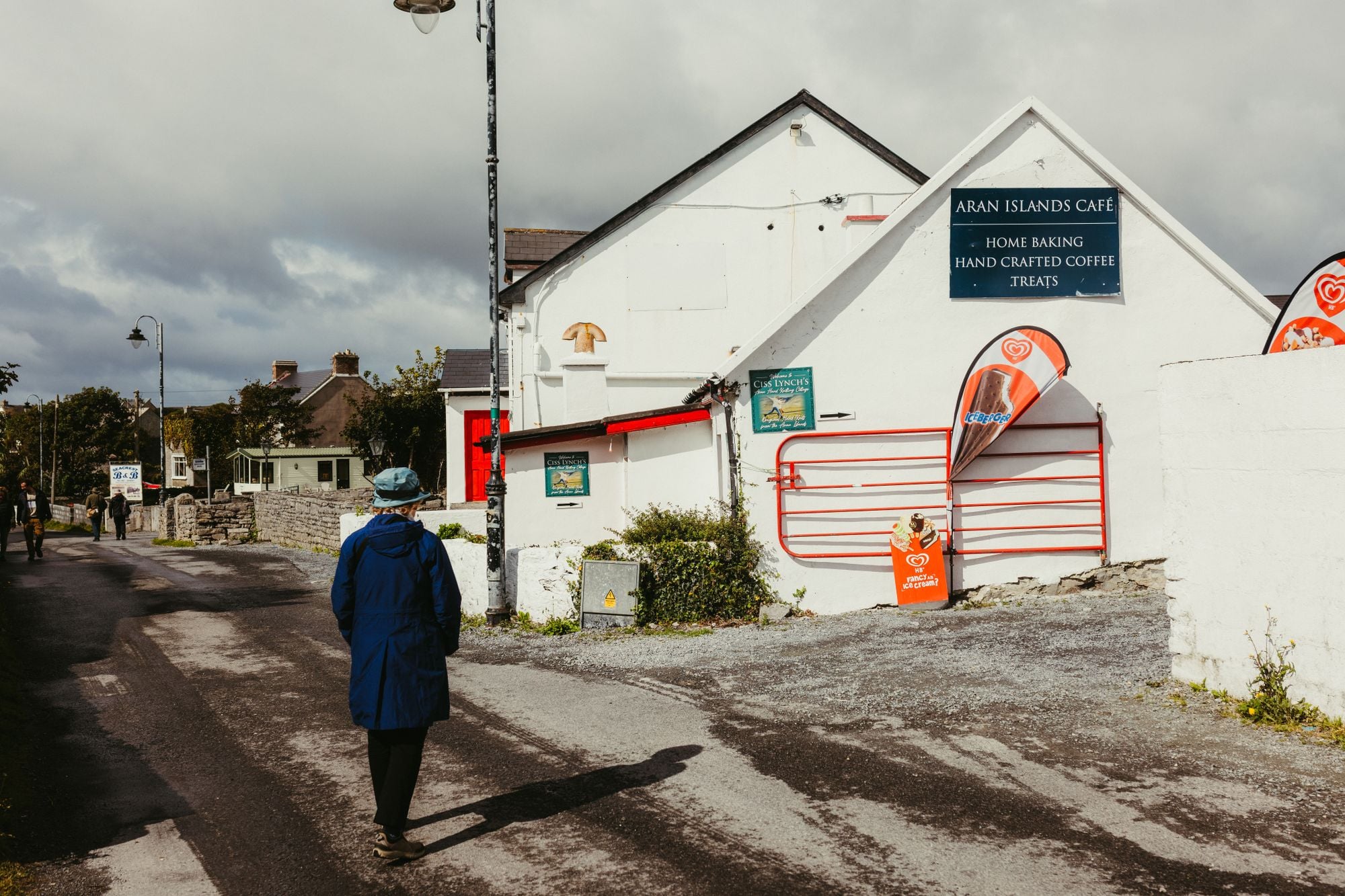 A quaint scene outside Aran Islands Cafe with a person walking down the street in County Galway, Ireland.