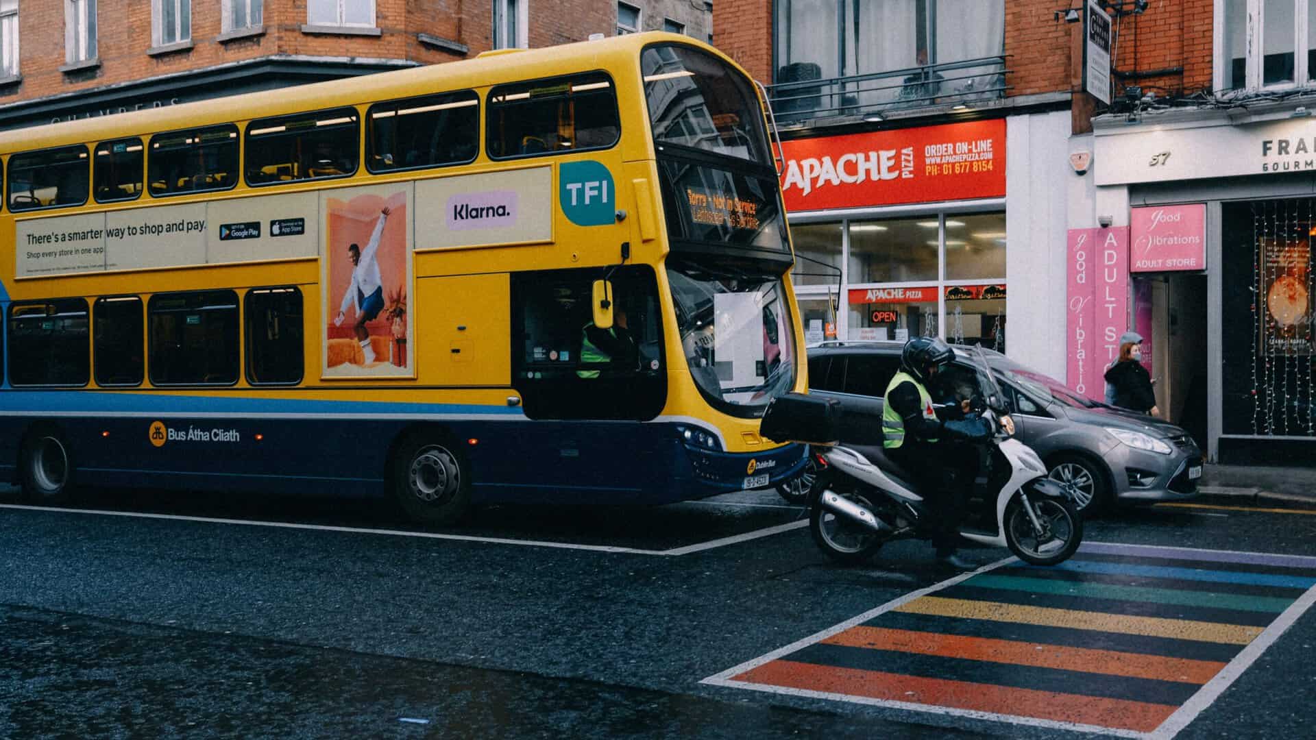 Dublin city bus and motorcycle at a street intersection.