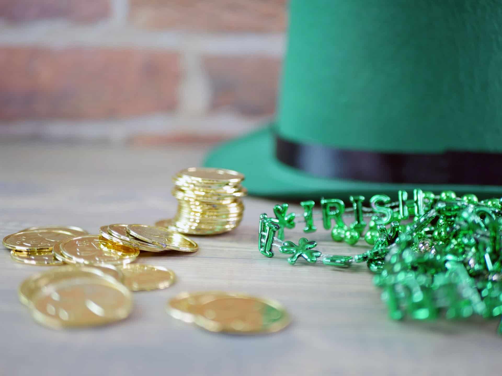 Close-up of gold coins and green beads with 'Irish' letters, perfect for St. Patrick's Day themes.
