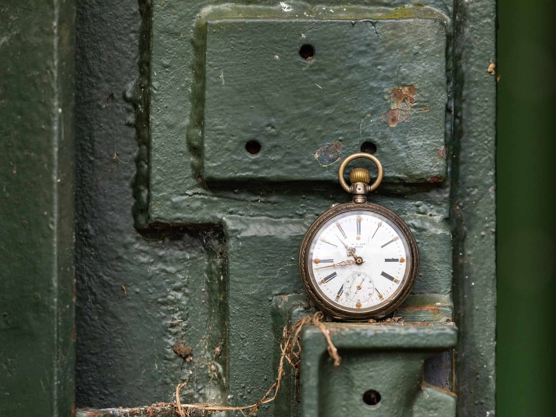 Pocket watch hanging on a green door in Ireland.