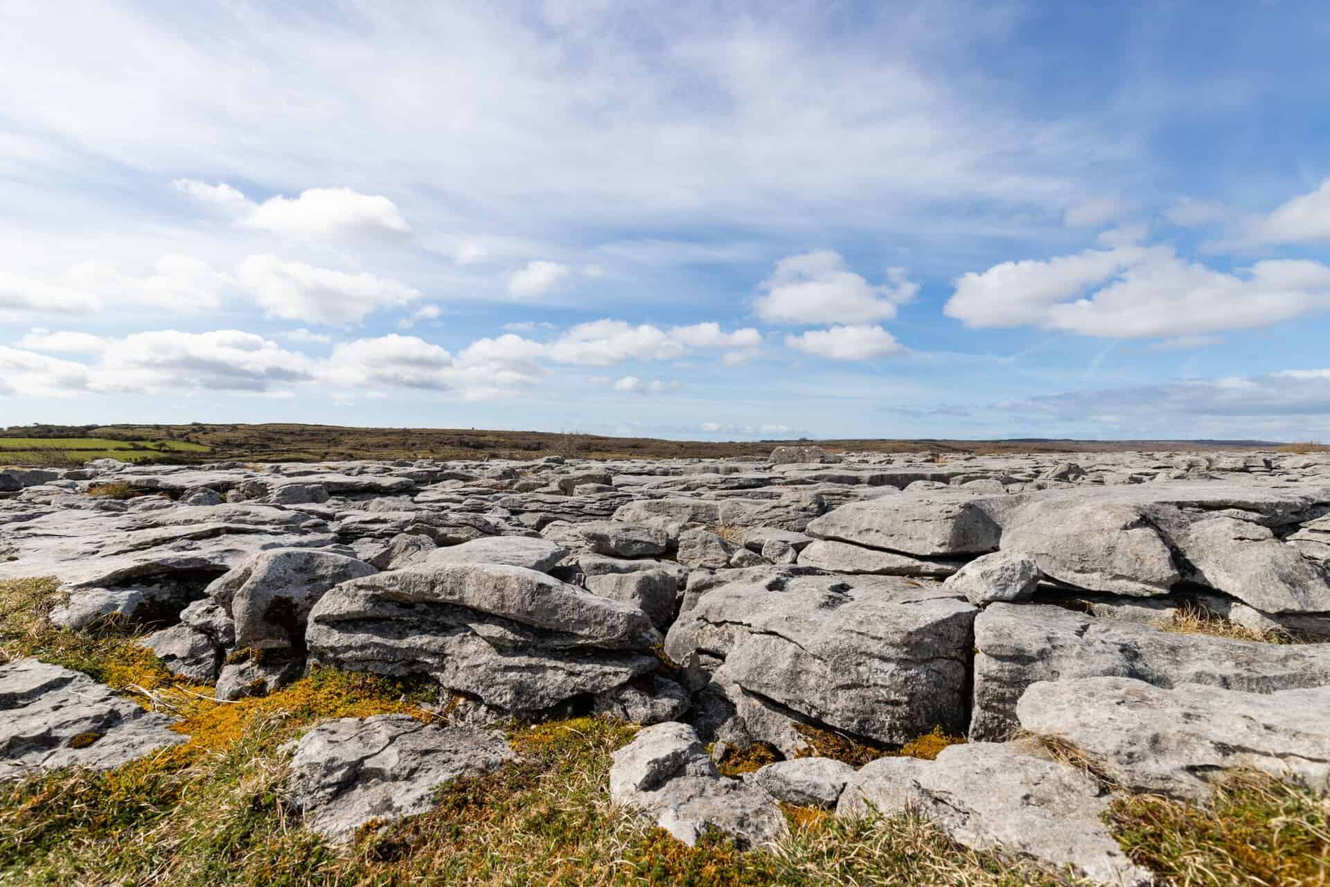Explore the unique limestone karst landscape of The Burren under a bright sky.