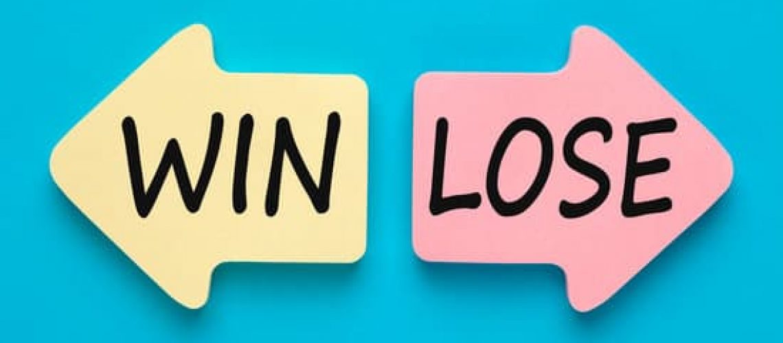 Win or lose written on two paper arrows on blue background. Business concept.