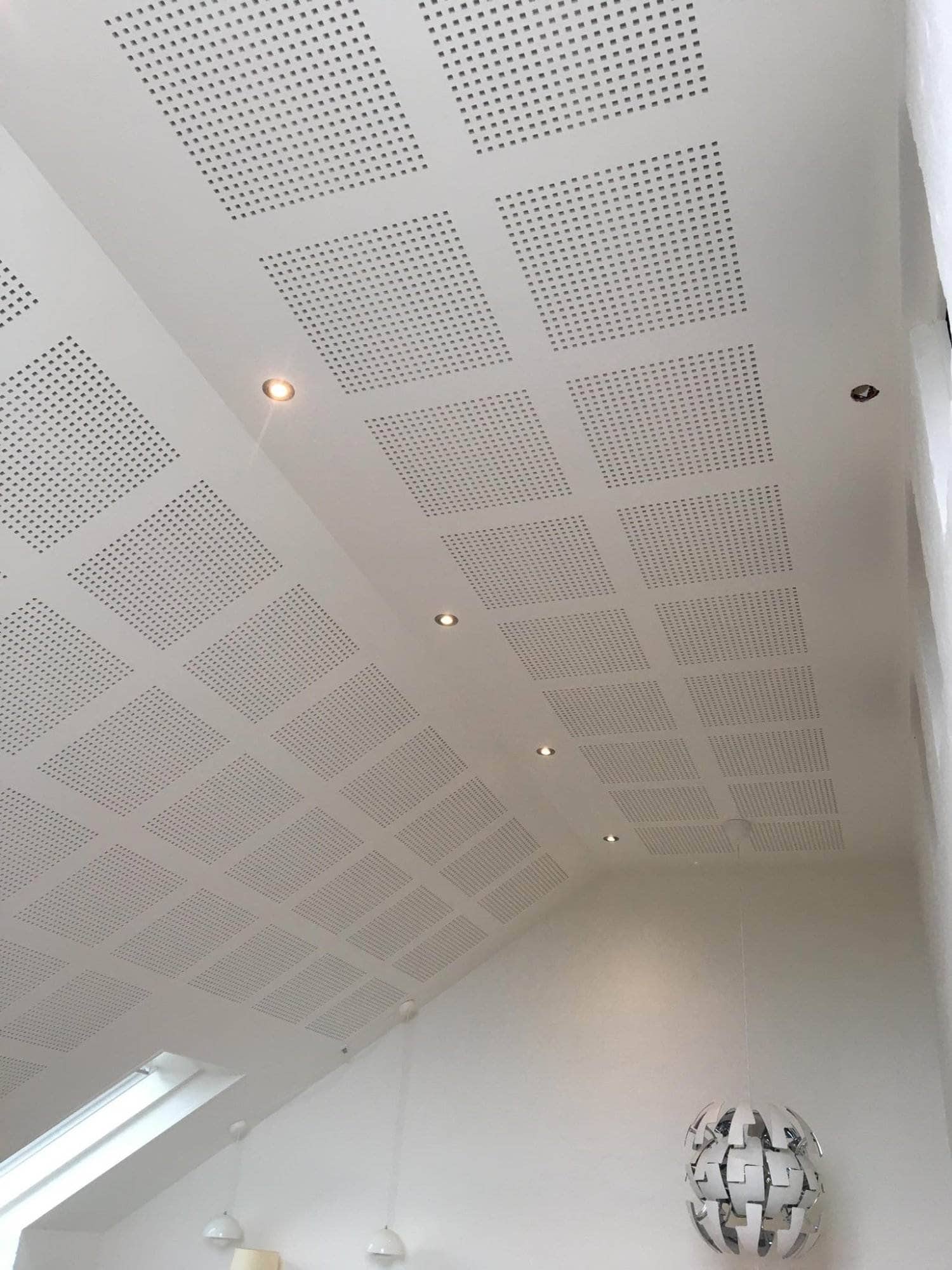 Lydabsorberende lofter med indbyggede spots til forbedret akustik og belysning.