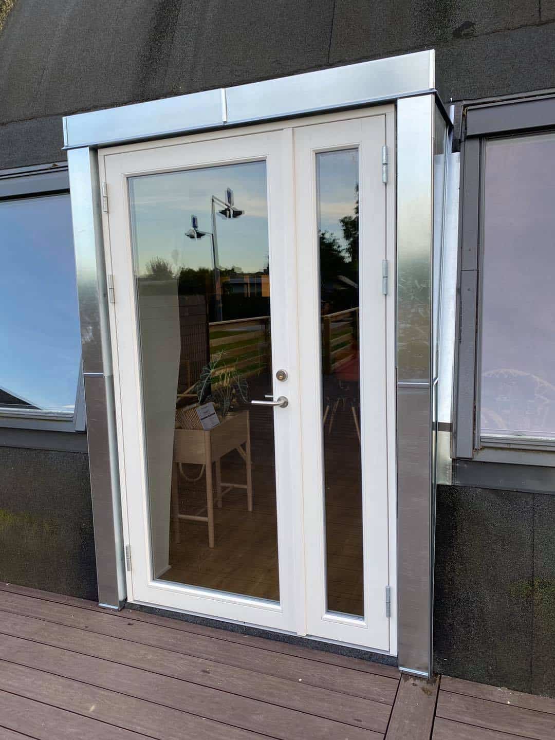 Glasdør til erhvervsbygning med aluminiumsramme og sidepanel.