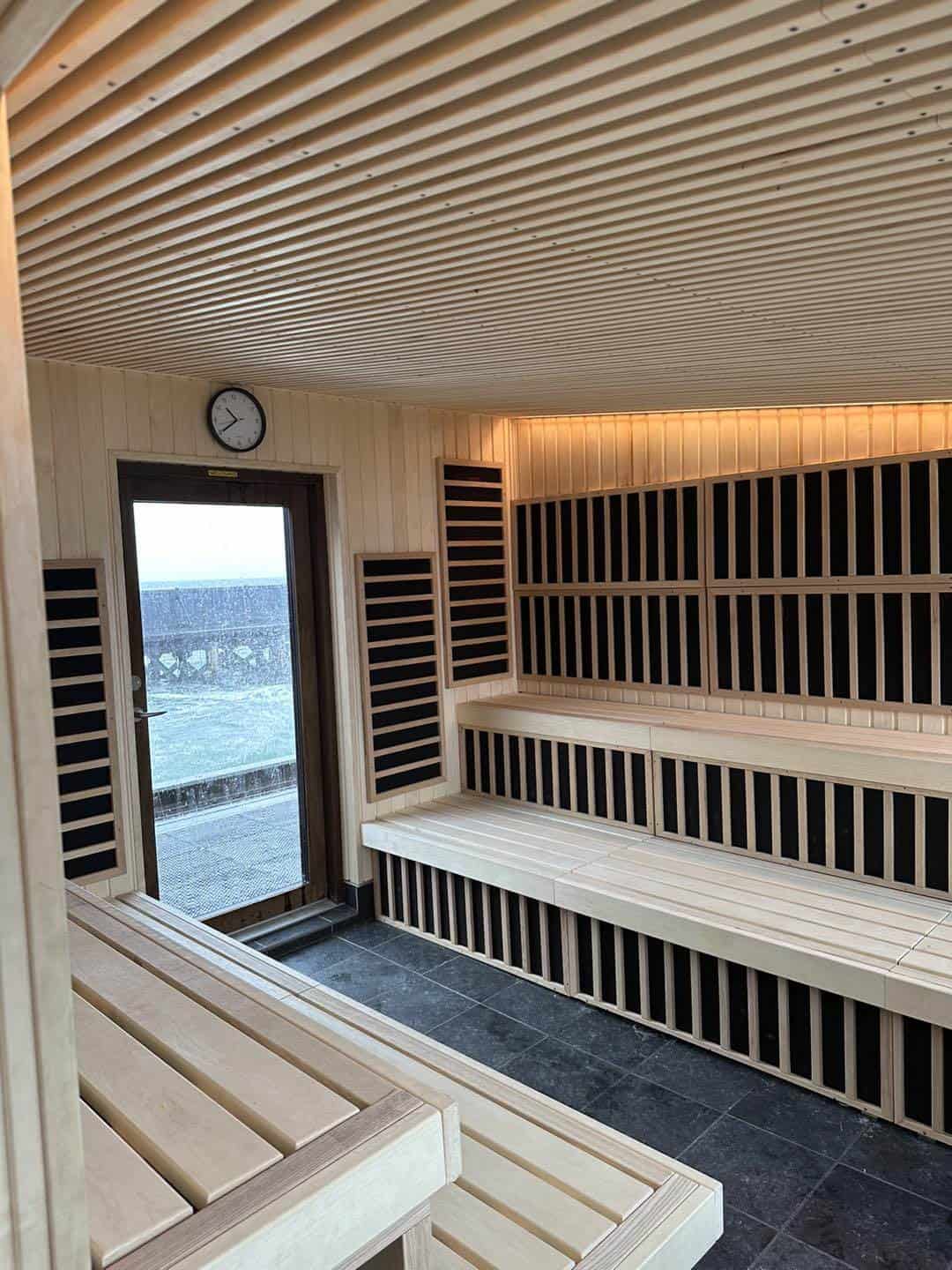 Udendørs sauna i asp-træ med træbænke og moderne design.