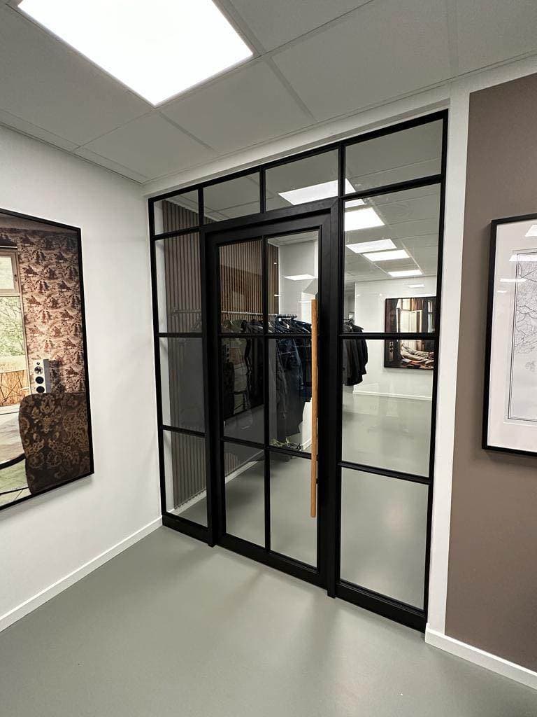 Moderne glasdør med sort ramme til kontorindretning.