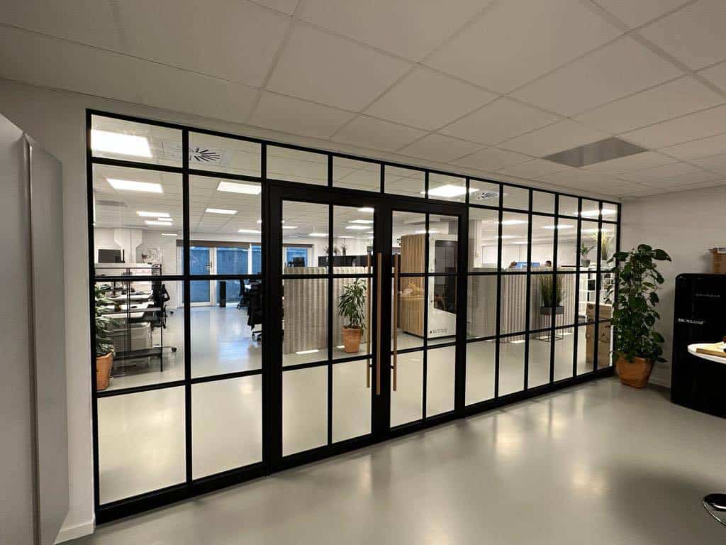 Moderne glasdør med sort ramme til kontorlokale.