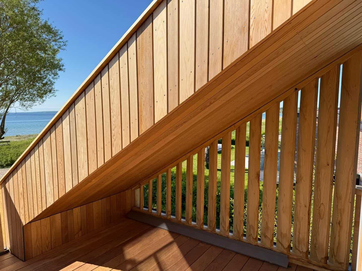 Træterrasse med skrå væg og udsigt over naturen.