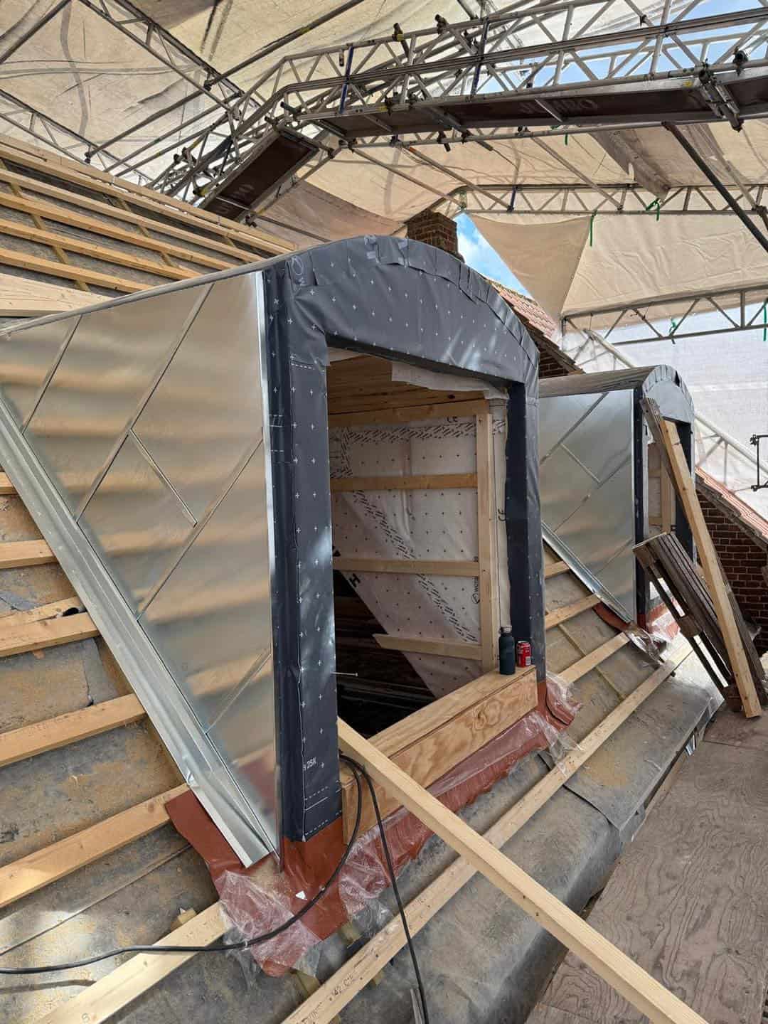 Ny tagkonstruktion med metalplader på ældre ejendom under renovering.