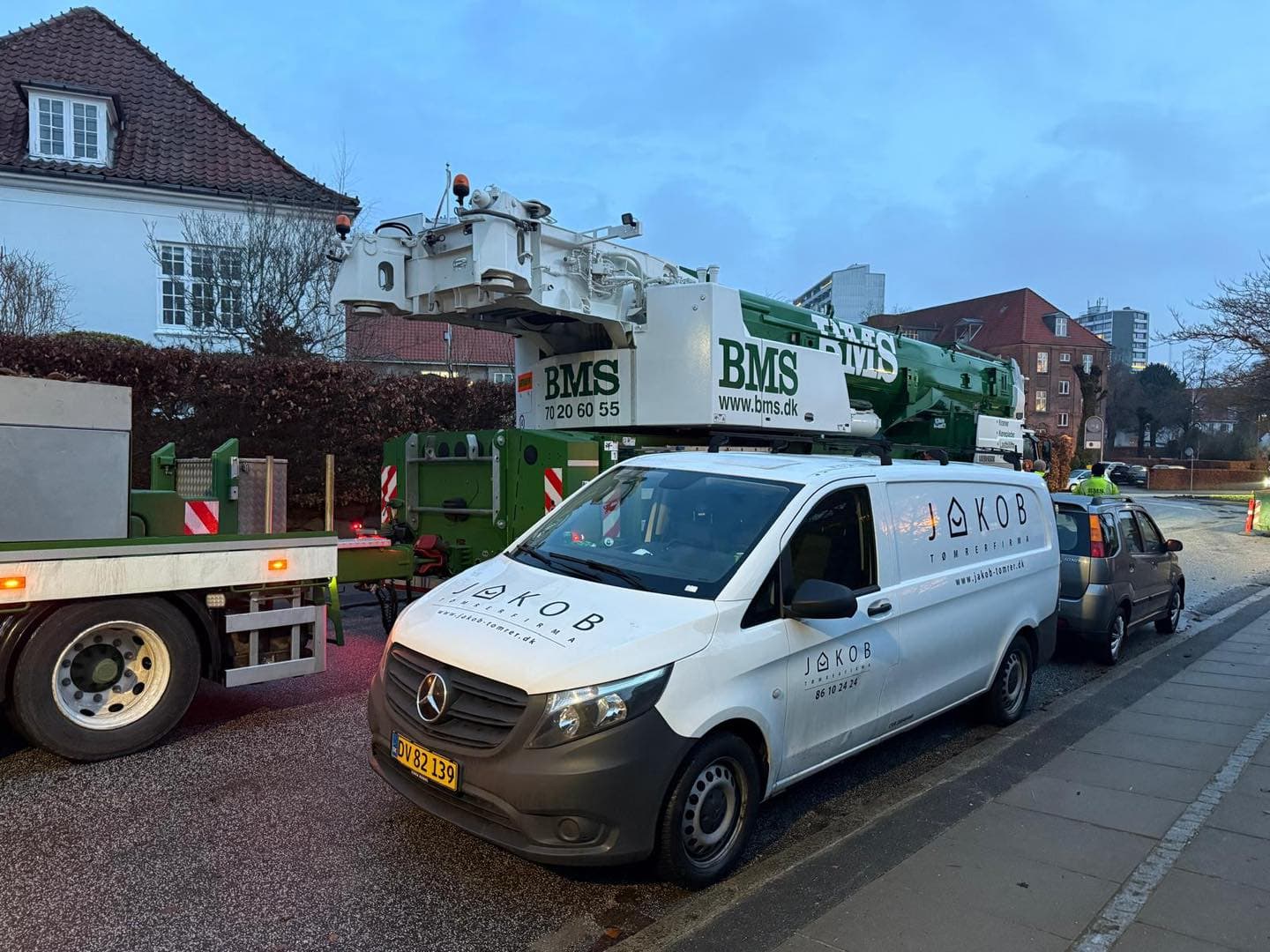 BMS kran og servicebil foran boligbyggeri i København.