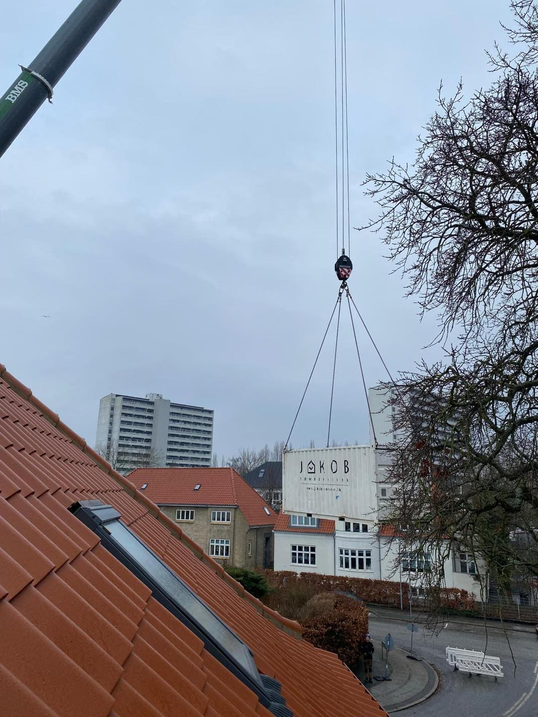 Tømrerfirma Jakob Tømrer A/S installerer skilt på bygning i København.