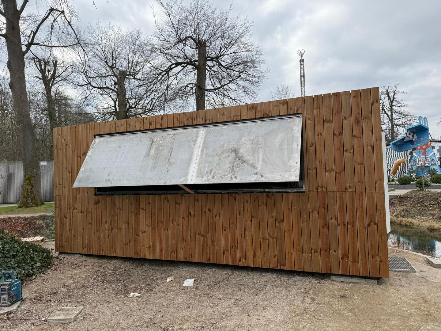 Træfacade med stort vinduesparti under opførelse.