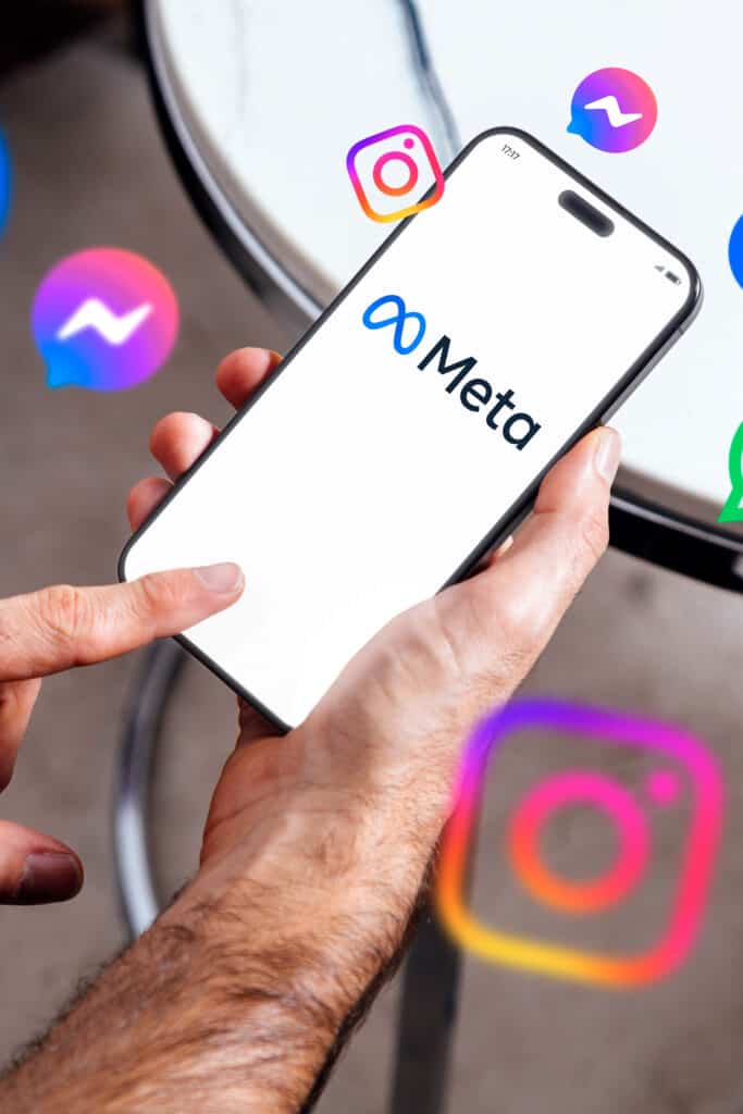 Meta logo on smartphone screen with social media app icons floating around, digital marketing theme.