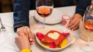 Valentine's Day romantic dessert with heart-shaped cake and rosé wine glasses.