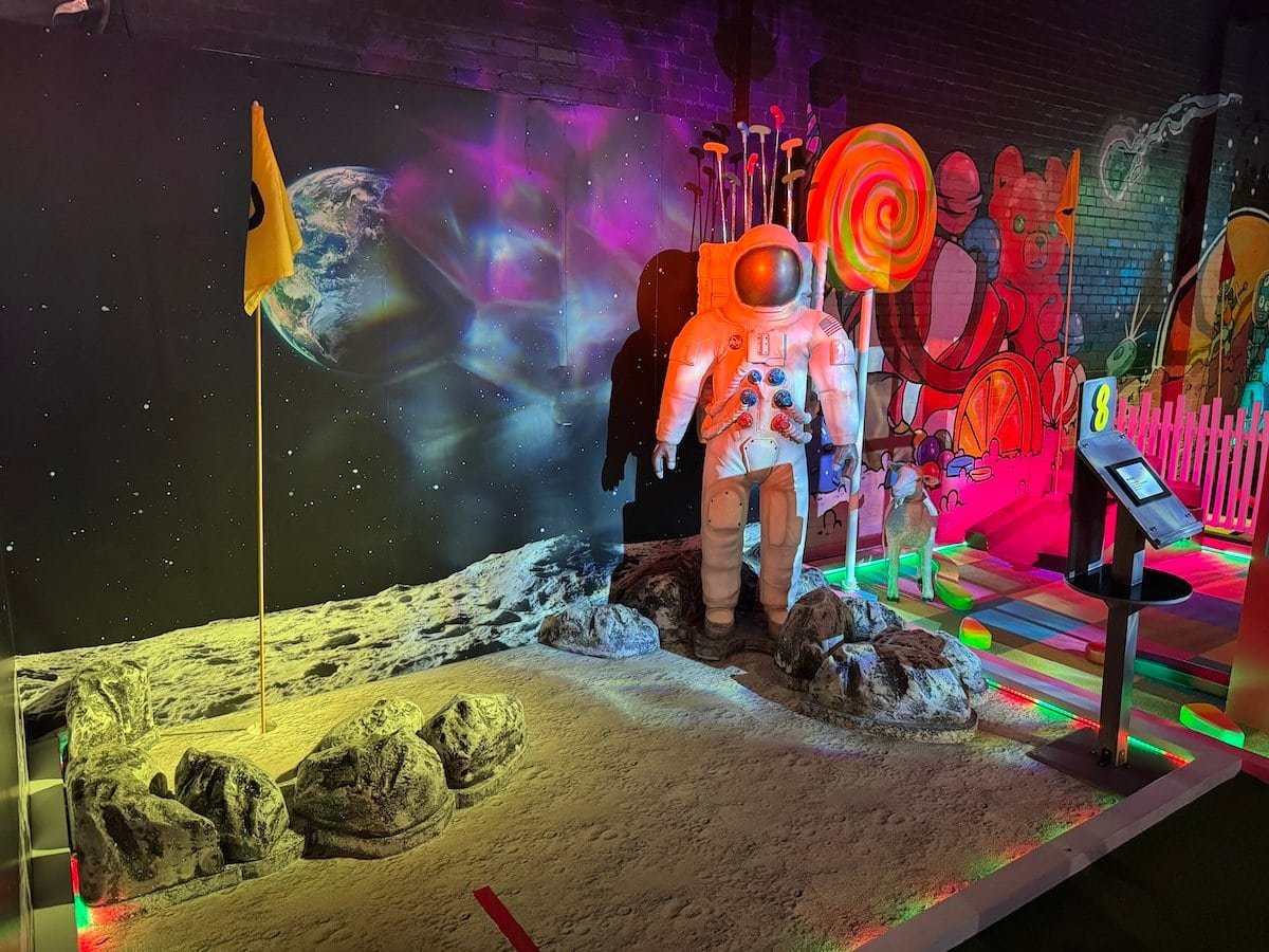 Two holes featuring vibrant art and props at Holey Moley.