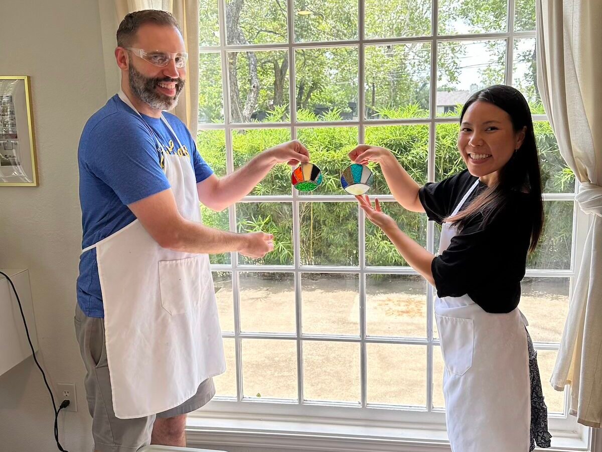 Two people exchanging colorful handmade trinkets at craft social event.