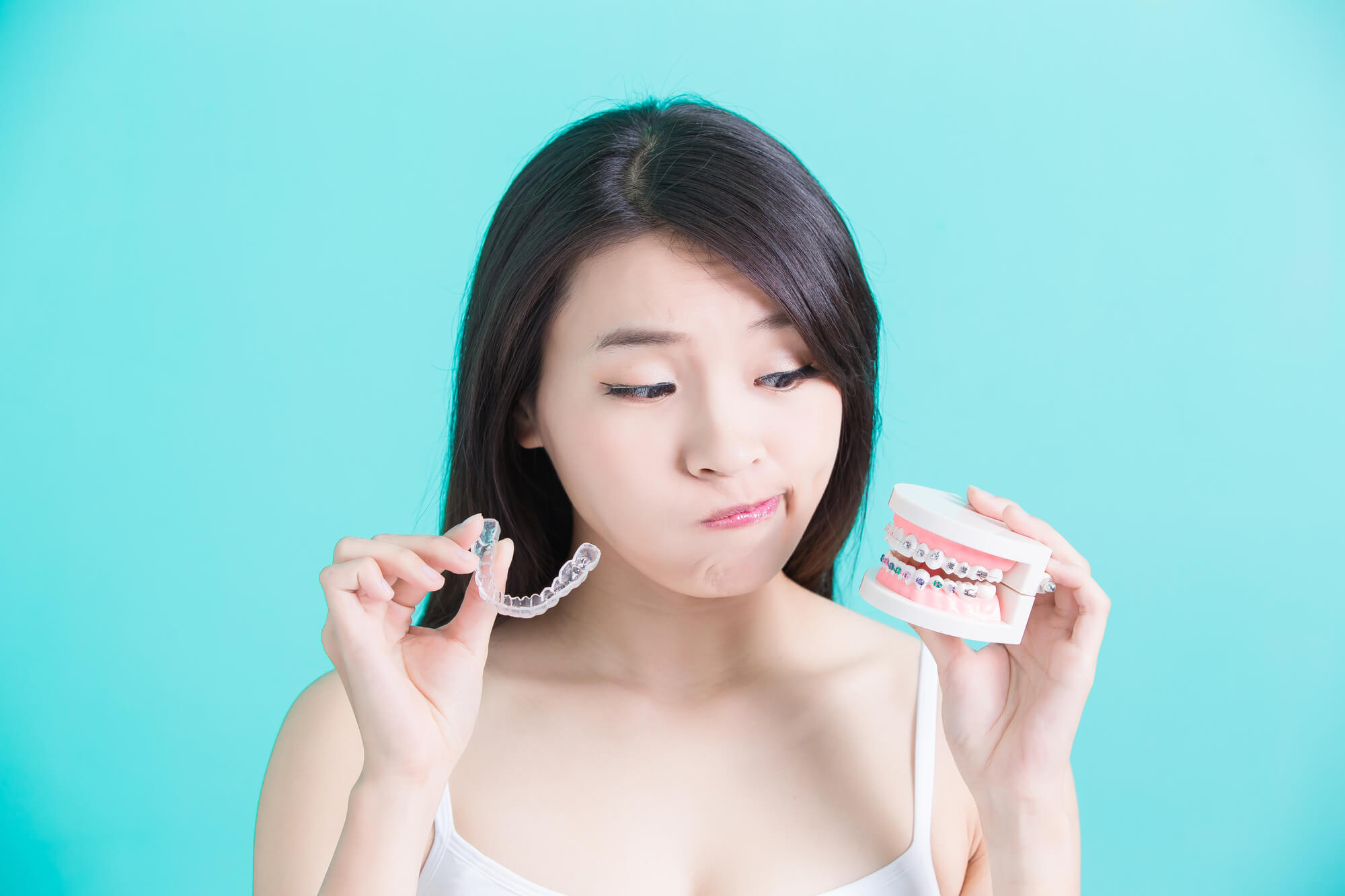 Woman choosing between Invisalign Woodland Hills and braces Woodland Hills for teeth straightening Woodland Hills.