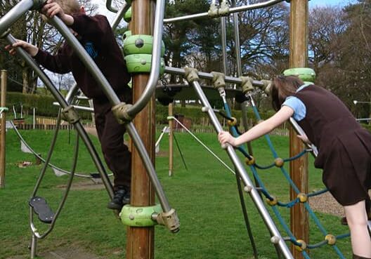 Children enjoying outdoor play on climbing equipment at Karen's Stars Childminding Services.