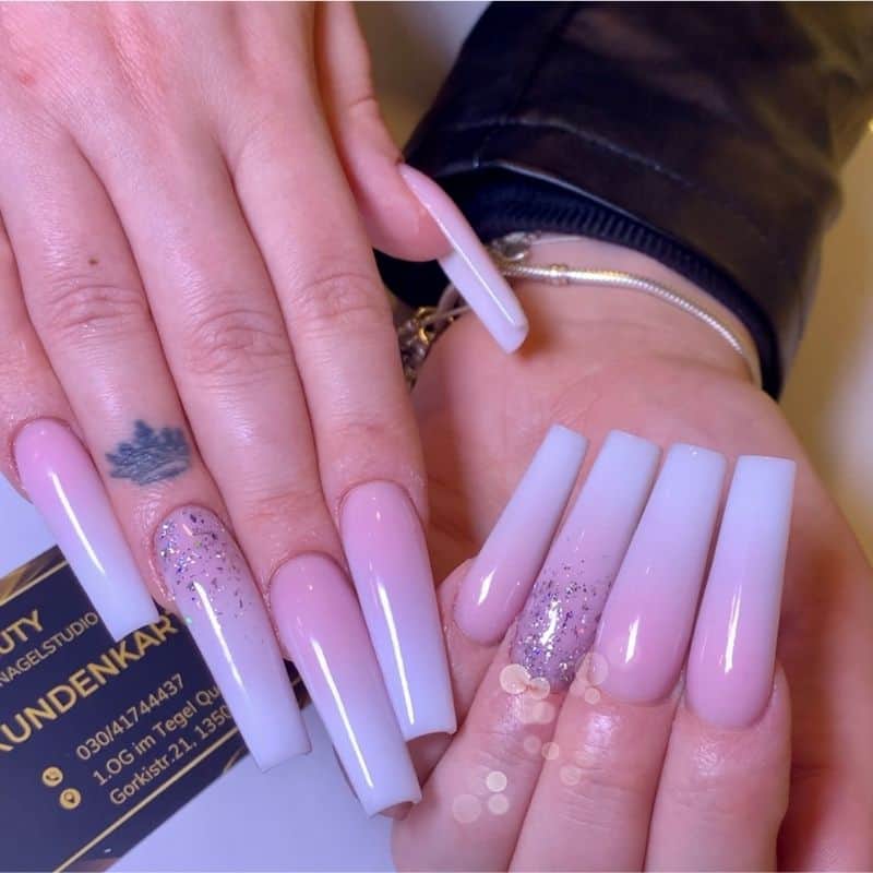 Elegante Nageldesigns mit Glitzer und Pastellfarben für einen stilvollen Look.