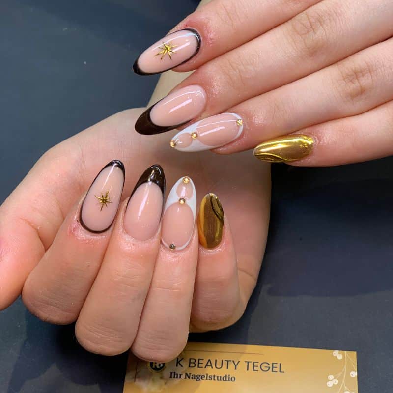 Elegante Nageldesigns mit Gold- und Schwarzakzenten in Berlin.