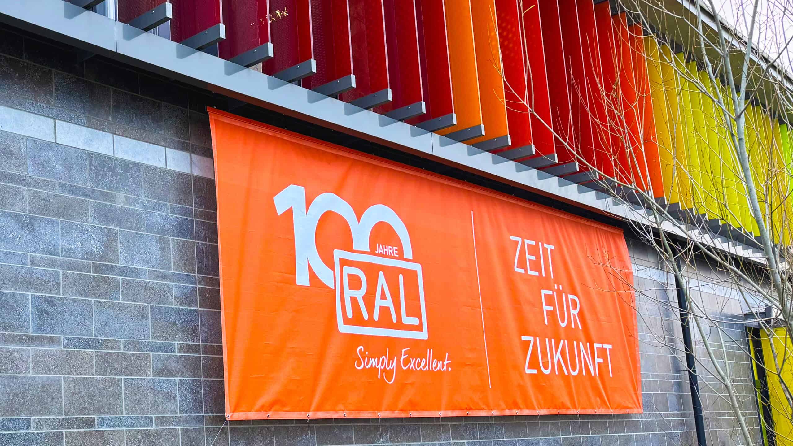 Orangenes Digitaldruck Banner im Großformat – Jubiläumswerbung und auffällige Bannerwerbung in RAL Farben für Events in Bonn