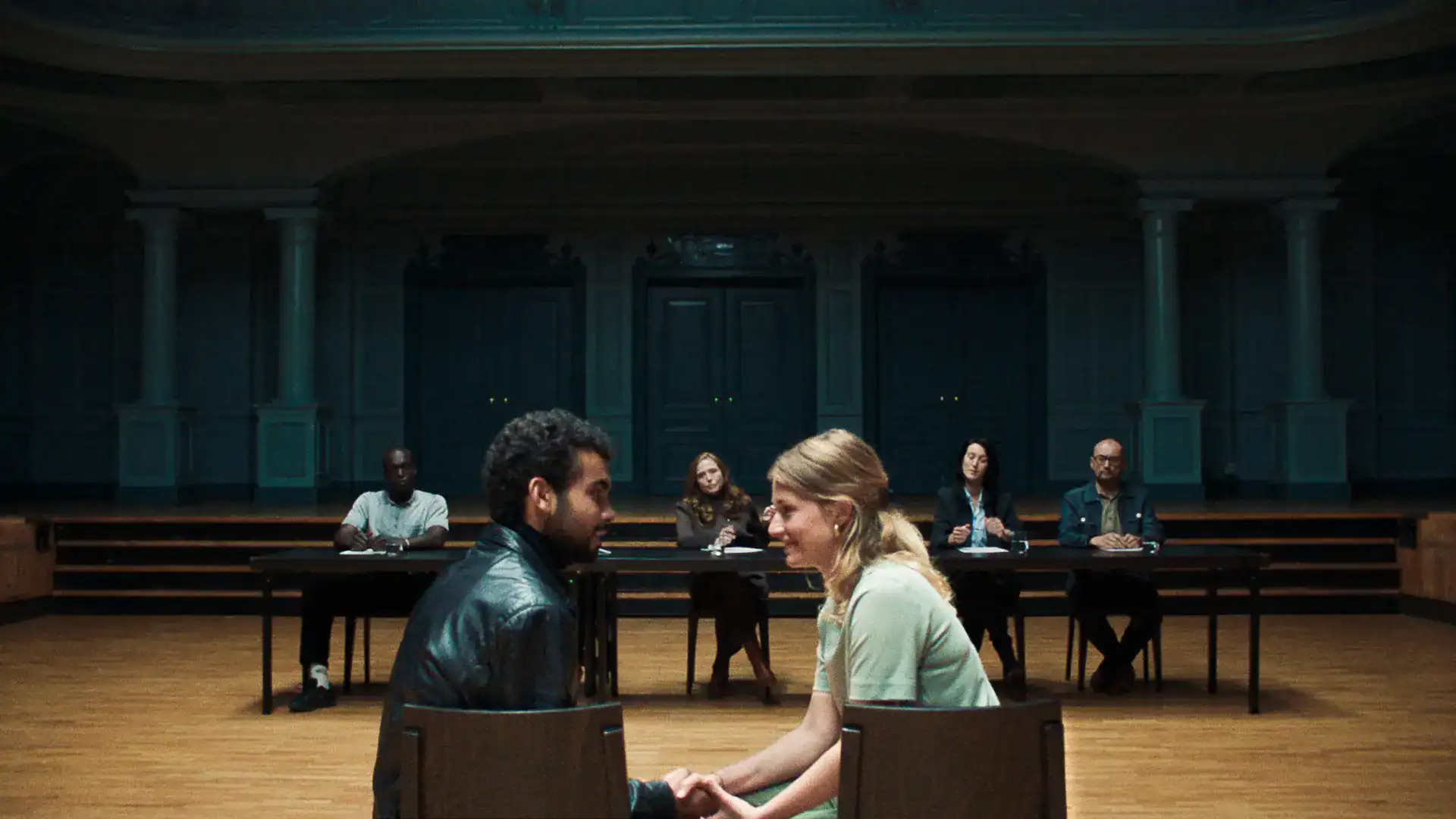 Actors and director during a theater rehearsal in a historic venue.