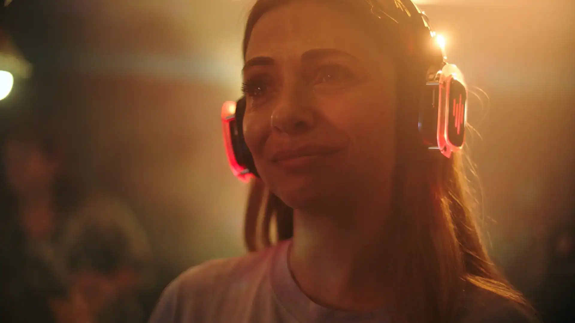 Woman wearing headphones in a vibrant, professional video production setting.