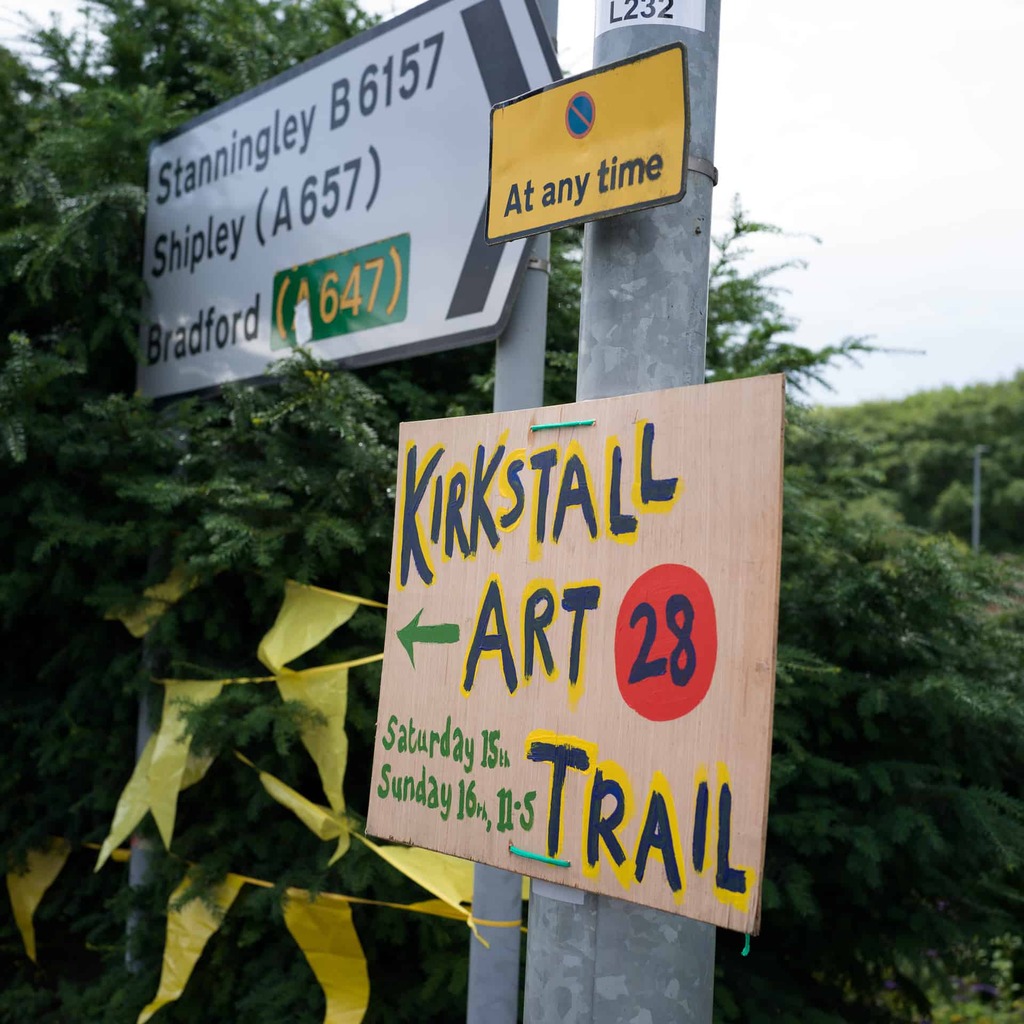 A sign for Kirkstall Art Trail attached to a lamp post.