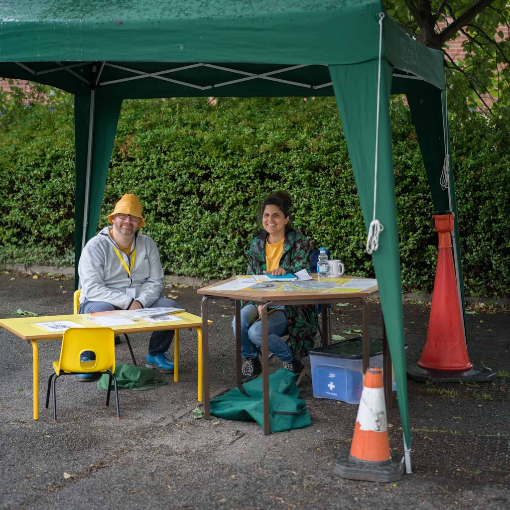 Two volunteers sit at the information table.