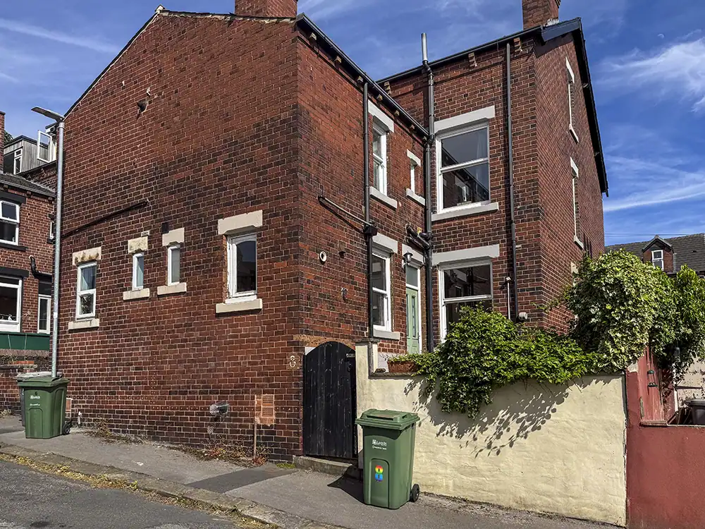 Exterior of 8 Hesketh Avenue, a red brick Victorian house, with a tarmac path and dropped kerb.
