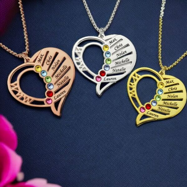The Multi Name with Birthstones Heart Necklace features gold, silver, and rose gold heart pendants engraved with Max, Chris, Nolan, Michelle, Natalie, and Lauren beside colorful gemstones on dark fabric with a purple drape and pink flowers.